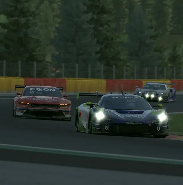 A McLaren GT3 in Altitude Freem colours running alongside a Mustang and another GT car through a tree-lined corner
