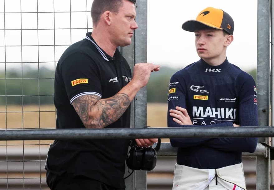 Revie Lake talking with a Mahiki Racing team member at the trackside fence at Snetterton