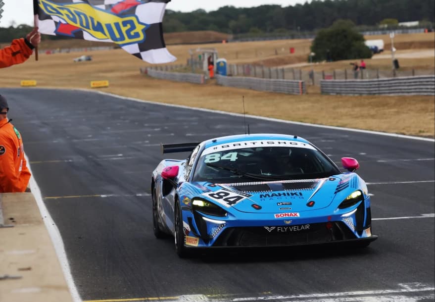 The number 84 Mahiki Racing McLaren Artura GT4 taking the chequered flag at Snetterton
