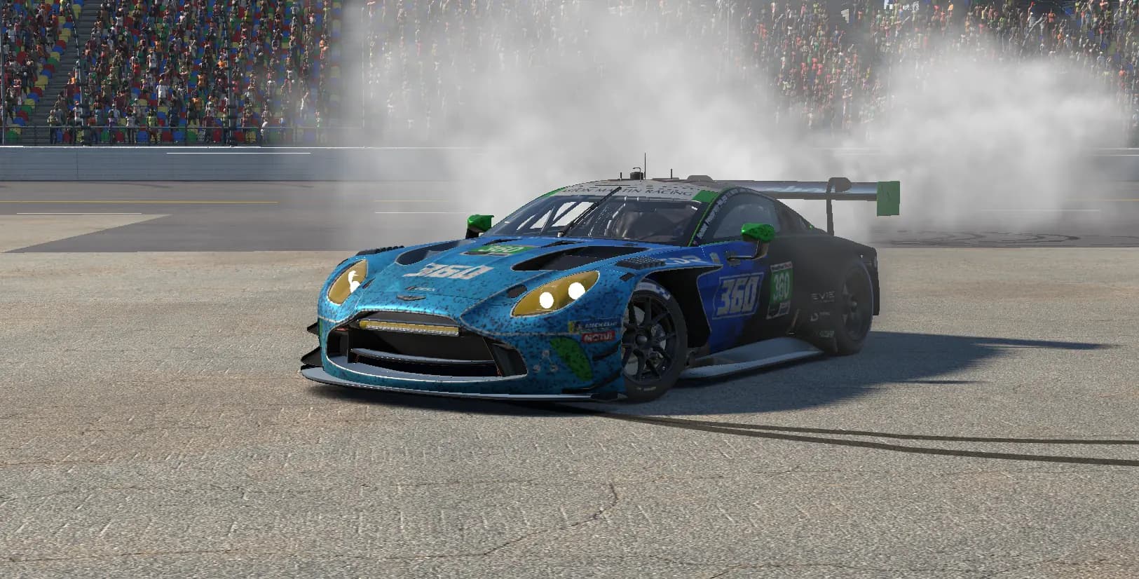 The number 360 Aston Martin Vantage GT3 pulling donuts in front of the Daytona grandstand